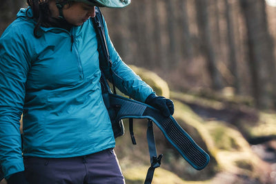 Bikerumor female mountain bike product tester showing EVOC Trail Pro 10L protector backpack elastic and velcro waist belt wings