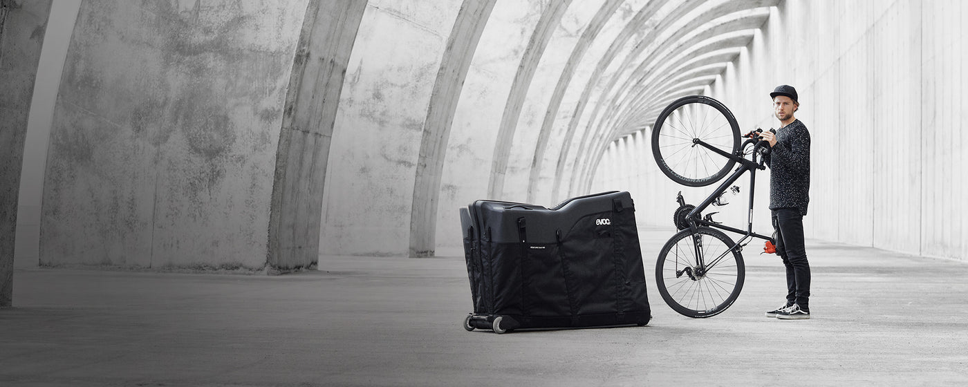 EVOC Bike Travel Bag next to man standing with bike