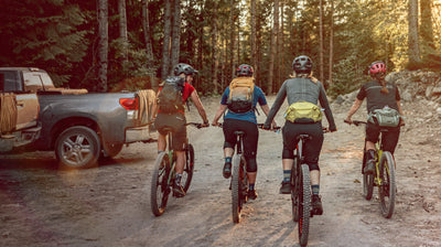 Female mountain bikers wearing EVOC hip packs and hydration backpacks