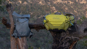 EVOC Hydro Pro hydration vest and EVOC Hip Pack Pro hanging side by side