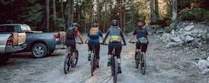 Women mountain bikers with EVOC hip packs, hydration backpacks, and tailgate pads in use