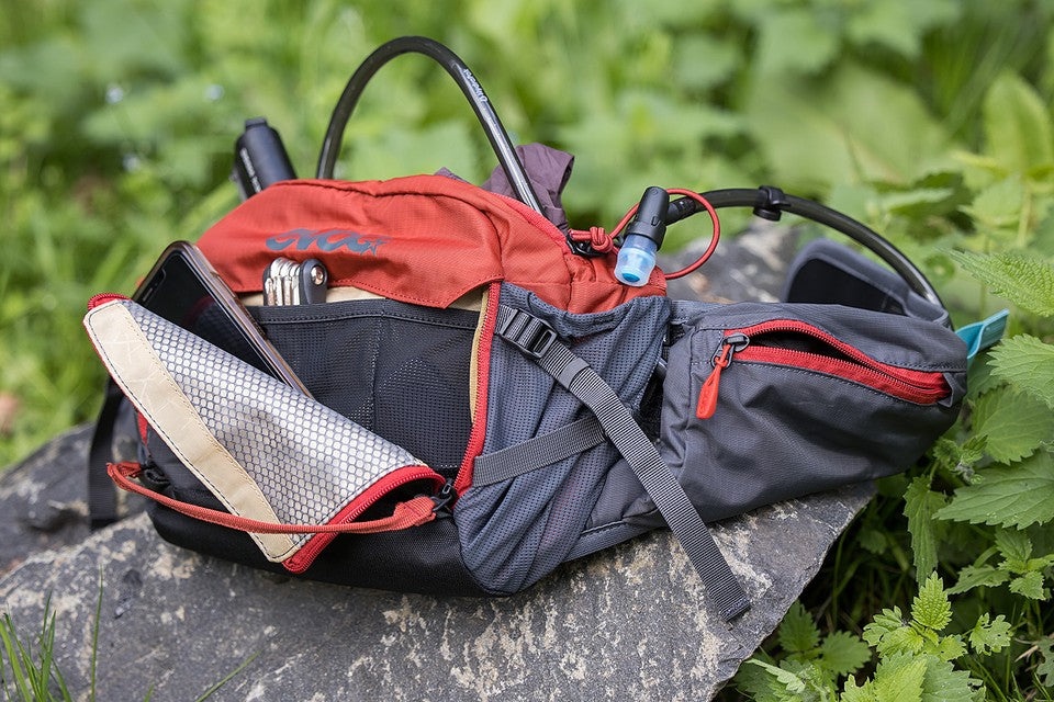 EVOC Hip Pack Pro shown with pockets open revealing storage options