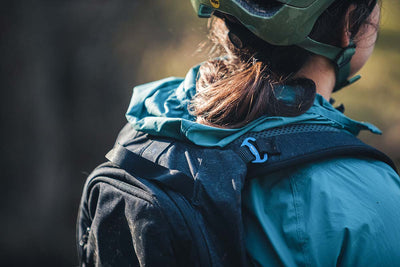EVOC Trail Pro 10L protector backpack worn by Bikerumor mountain bike product tester woman showing padded pack straps with self-aligning brace links
