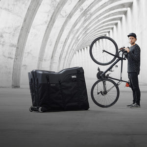 EVOC Bike Travel Bag next to man standing with bike mobile view