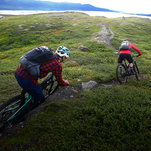 Mountain bikers wearing EVOC backpacks and riding Scandinavian singletrack mobile view