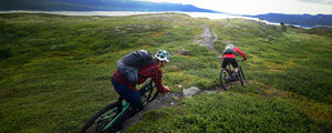 Mountain bikers wearing EVOC backpacks and riding Scandinavian singletrack