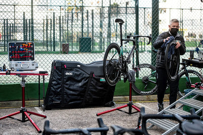 BORA-hansgrohe team cycling mechanic works on bike with EVOC Road Bike Pro Bag alongside