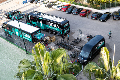 EVOC sponsored BORA hansgrohe cycling spring team training camp set up with bikes, busses, and support vehicles with palm trees all around