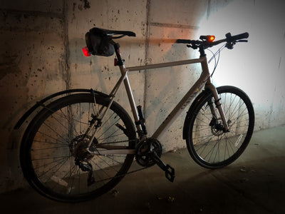 EVOC seat bag with red bike light attached to commuter bike with bright headlight shining in the dark