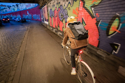 Bike commuter wearing EVOC waterproof backpack riding a bike with protective fenders