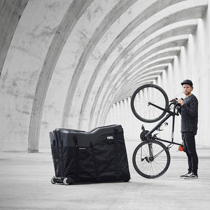 EVOC Bike Travel Bag next to man holding bike upright mobile view