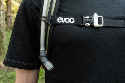 EVOC Stage 6L backpack shoulder strap with hydration bladder hose attached and emergency whistle on chest strap clip as shown in Freehub Magazine review