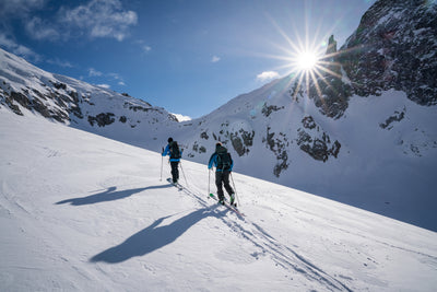 EVOC backpacks worn by ski touring couple in the mountains